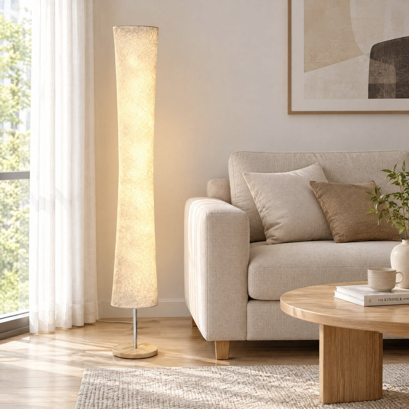 Lit floor lamp beside a sofa and coffee table in a living room