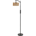Black arched floor lamp with woven paper rope shade on a round base
