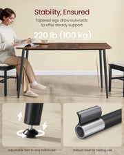 Woman working at the walnut table showing the outward tapered black legs