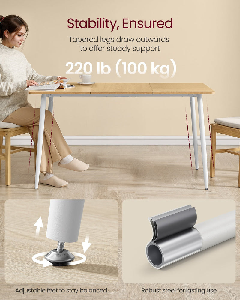 Woman seated at the Golden Oak table showing the outward tapered white legs and adjustable feet