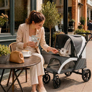 Woman feeding her dog a treat while it sits inside the pet stroller at a cafe
