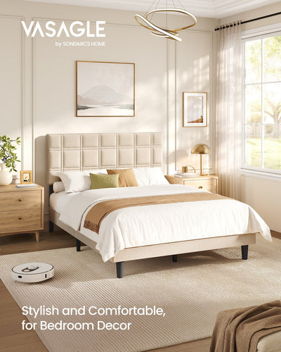 Upholstered double bed in a bright bedroom with a robot vacuum passing under the raised frame