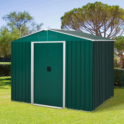 Green 8x6ft metal garden shed with closed double sliding doors standing on a lawn in front of tall trees