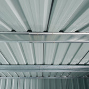 View up into the shed roof showing pale ribbed roof panels carried on galvanised steel support beams