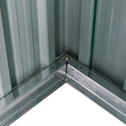Inside corner of the shed showing the galvanised steel base rail bolted to the pale interior wall panels