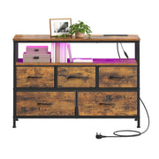 Open shelf styled with a framed photo, plant and storage boxes above the fabric drawers