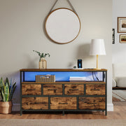 Dresser under a round wall mirror with blue LED lighting glowing on the open shelf