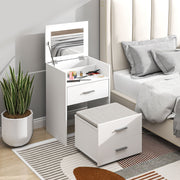 White dressing table and stool in a bedroom beside a bed with the mirror open