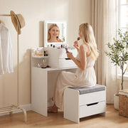 Woman using the vanity mirror while seated on the stool