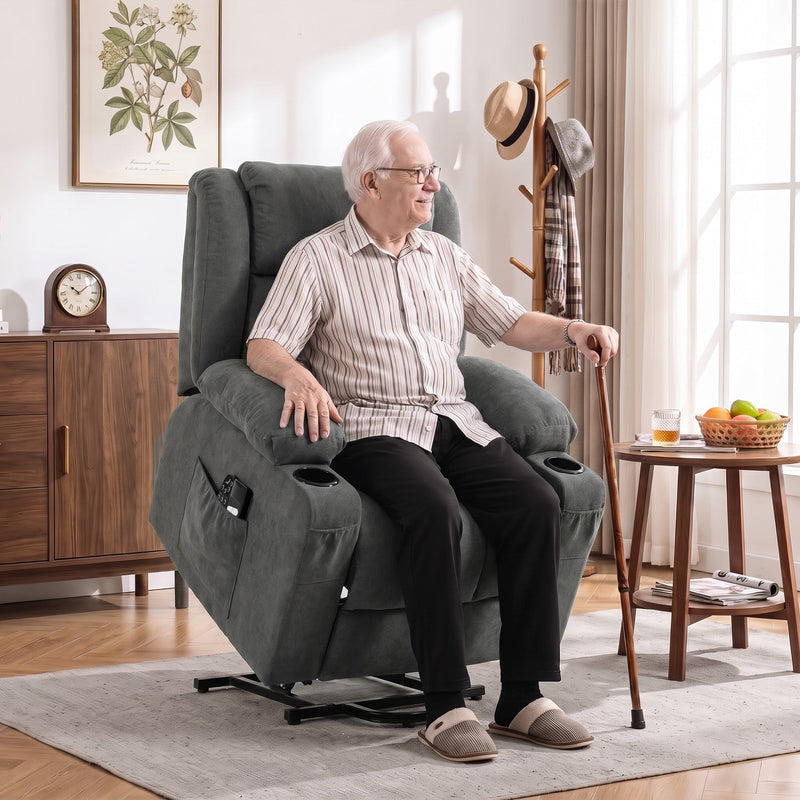 Elderly man using the electric lift function to stand from the dark grey recliner