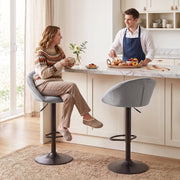 Woman sitting on a light grey Homcom bar stool at a marble kitchen island