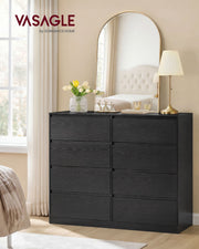 Black 8 drawer chest in a bedroom beneath an arched mirror and table lamp