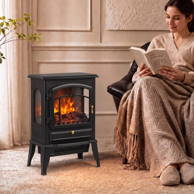 Black electric fireplace stove in a living room with a woman reading beside it