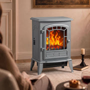Grey electric fireplace stove in a living room beside a candlestick and books