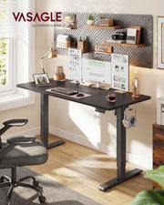 Standing desk in a home office with a pegboard wall, monitors and headphones on the side hook