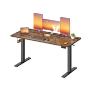 Three-quarter studio view of the standing desk with a monitor setup and headphone hook
