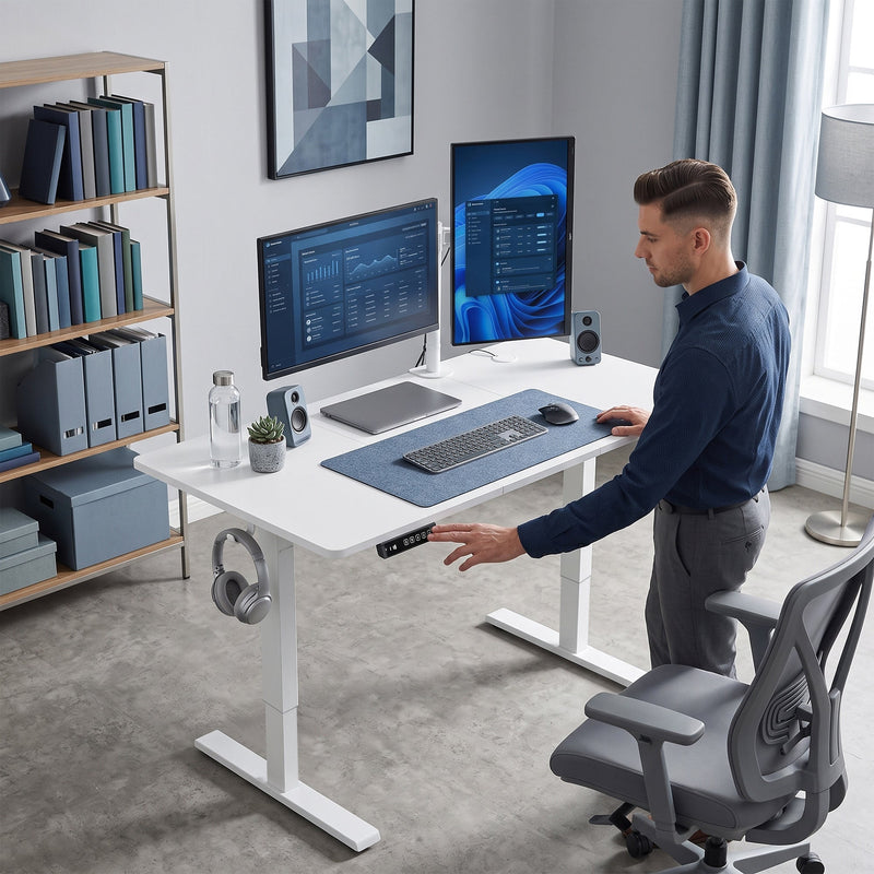 White standing desk in a home office with a person adjusting the height while standing