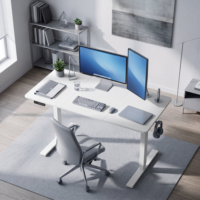 White standing desk in a home office viewed from above with a desk chair and shelving