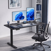 Black standing desk set up as a home office with two monitors and a desk chair