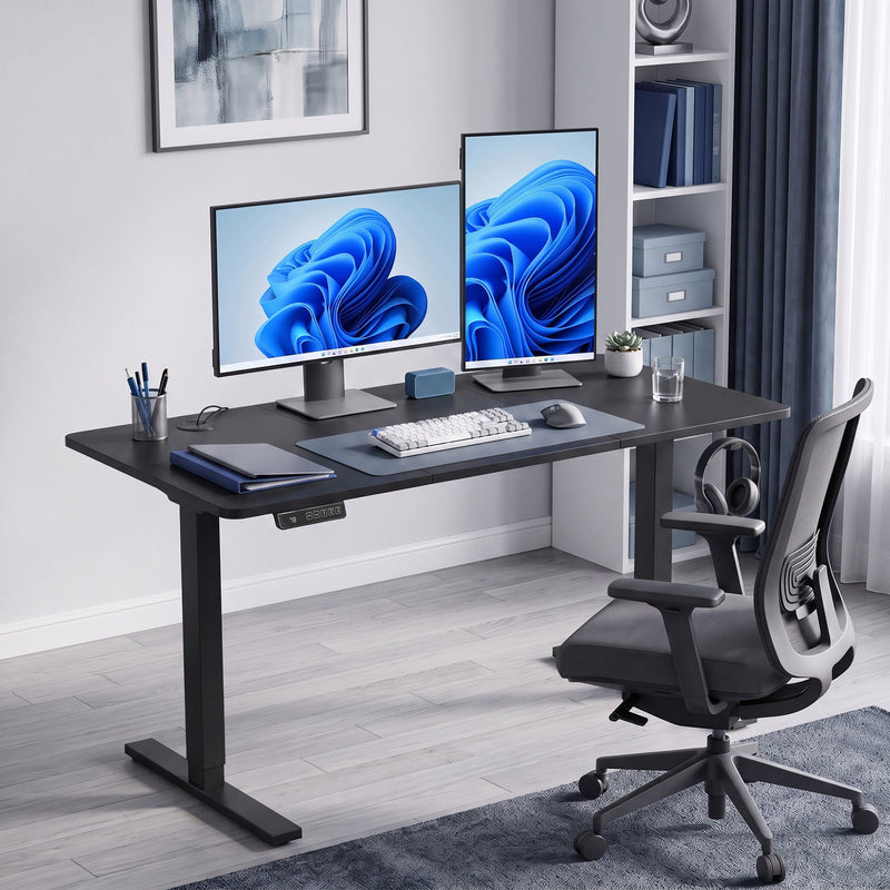 Black standing desk set up as a home office with two monitors and a desk chair