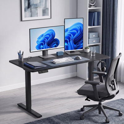 Black standing desk set up as a home office with two monitors and a desk chair
