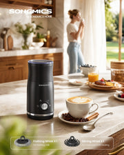 Milk frother on a kitchen worktop next to a latte, with the frothing whisk and stirring whisk shown below