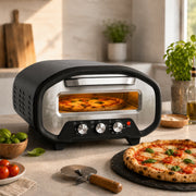 Electric pizza oven with dial controls on a kitchen worktop baking a margherita pizza beside a finished pizza on slate