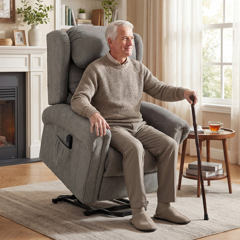 Older man using a walking cane getting up from the dark grey riser recliner beside a fireplace