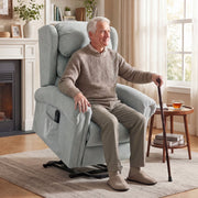 Elderly man sitting in the grey Homcom recliner chair beside a fireplace with a walking cane