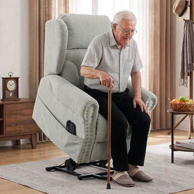 Elderly man using a walking cane to get up from the riser recliner chair in the lifted position