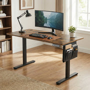 Standing desk in a home office with a curved monitor, keyboard and desk lamp