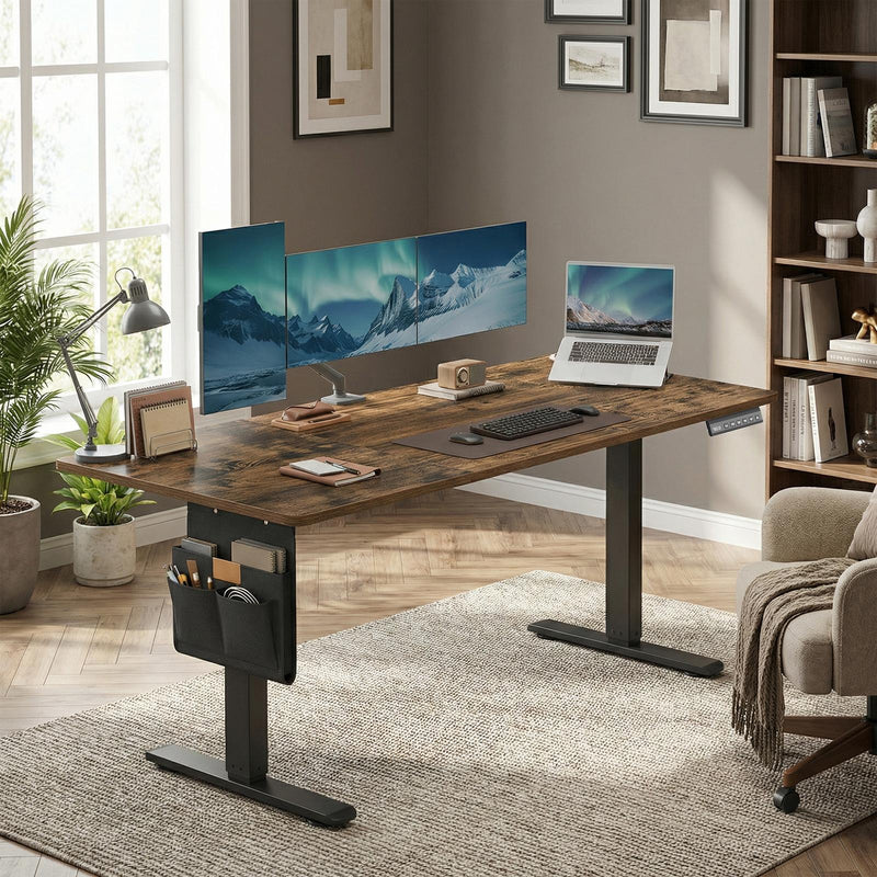 Standing desk fitted with a triple monitor setup and laptop in a living room office