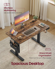 Overhead angle of the rustic brown desktop with a laptop, keyboard, monitor and coffee cup