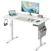 White electric standing desk with a monitor, keyboard, side storage pocket and headphone hook