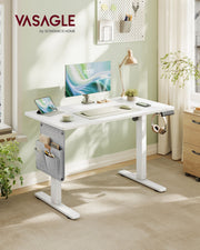 Vasagle white standing desk in a home office with a pegboard, desk lamp and plants