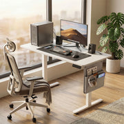 Vasagle standing desk in a home office with PC tower, monitor, speakers and ergonomic chair