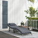 Image of an ergonomic curved rattan sun lounger with dark grey cushion