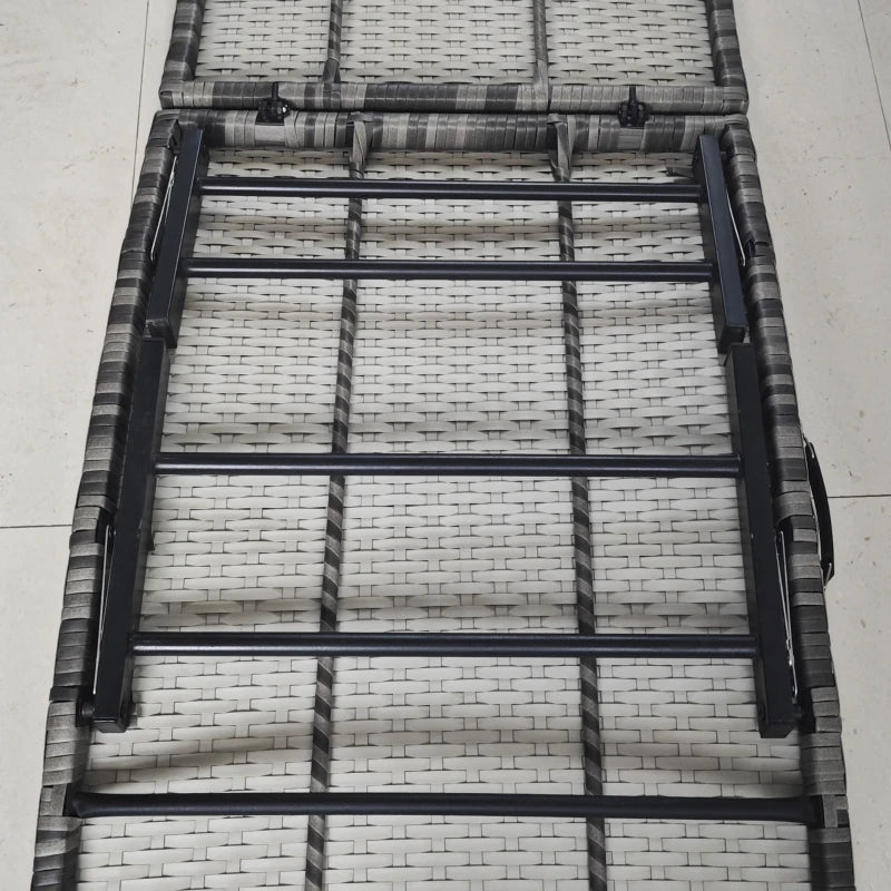 Image of an ergonomic curved rattan sun lounger with dark grey cushion