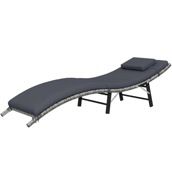 Image of an ergonomic curved rattan sun lounger with dark grey cushion