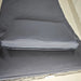 Image of an ergonomic curved rattan sun lounger with dark grey cushion