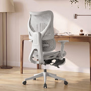 Rear view of a grey mesh office chair at a wooden desk by a window