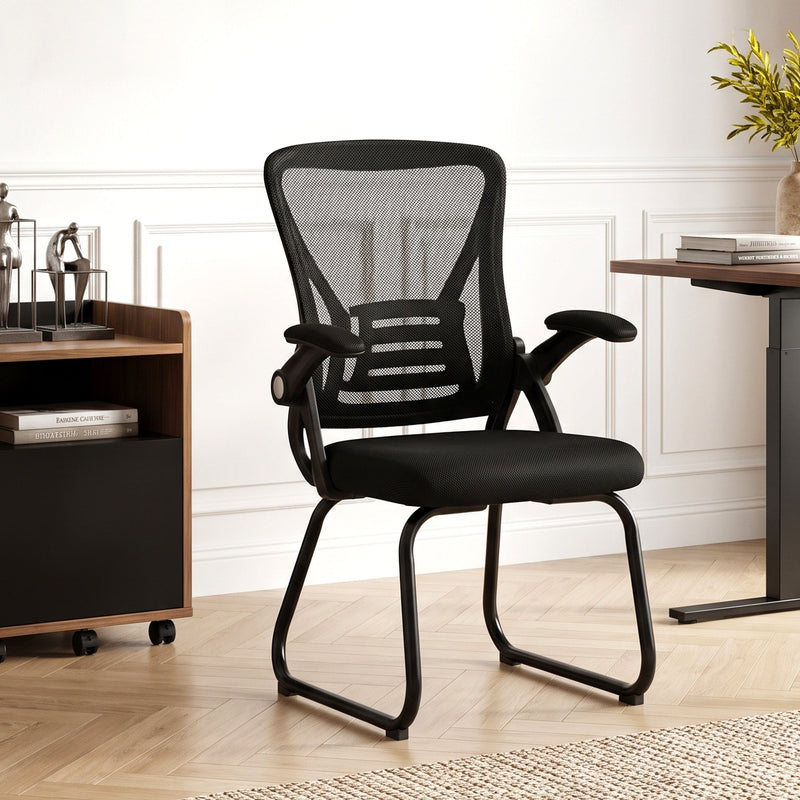 Person stretching while seated in the Black mesh office chair, showing the breathable backrest