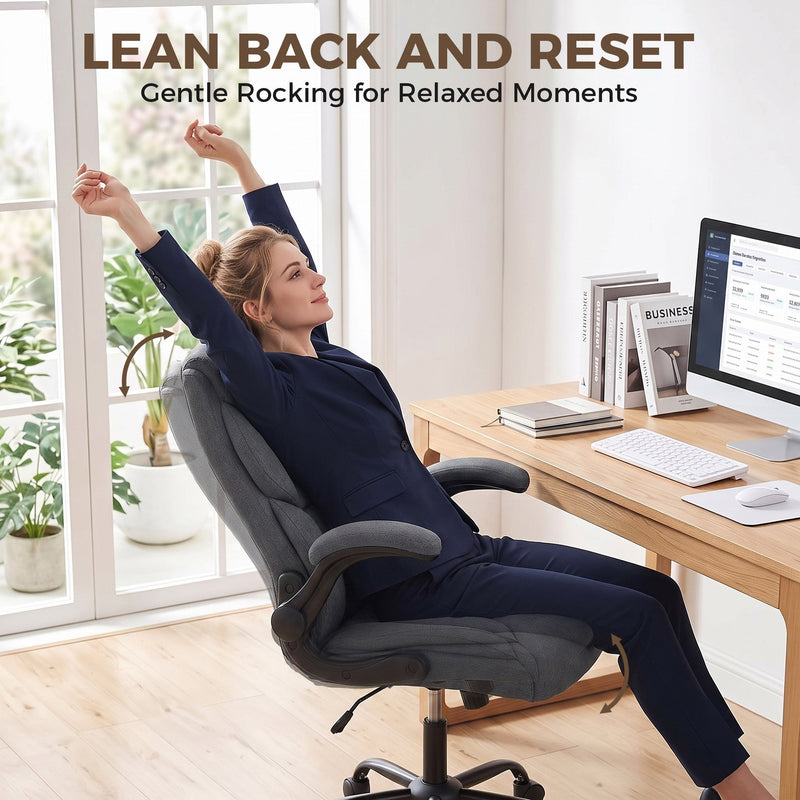 Woman stretching back in the rocking dark grey office chair at her desk