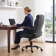 Woman in a navy suit working on a laptop in the dark grey office chair