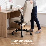Cream white chair with a flip-up armrest raised and the chair sliding under a wooden desk