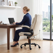 Woman in a navy suit working on a laptop in the cream white office chair