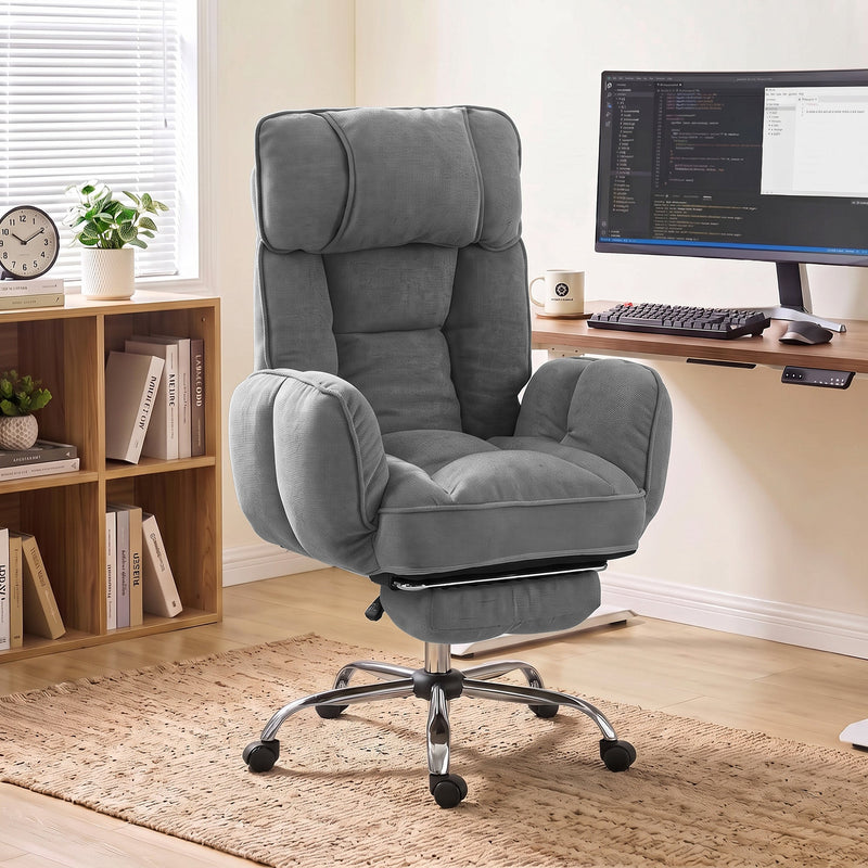 Dark grey executive office chair in a home study beside a wooden desk and bookcase