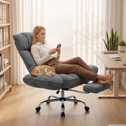 Woman reclining in the dark grey chair with the footrest out and a cat on her lap