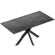Black marble effect extendable dining table with black steel cross legs on a plain background