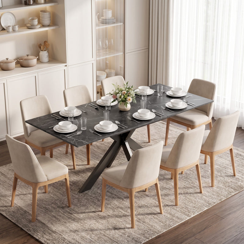 Black marble effect extendable dining table laid for dinner with beige chairs